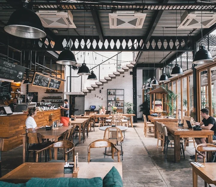 Cafe interior with long tables and a pastry counter